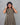 Woman wearing a patterned dress against a gray background