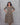 Woman wearing a patterned dress against a gray background