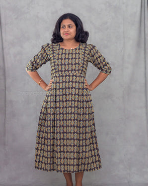 Woman wearing a patterned dress against a gray background