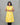 A women wearing yellow color cotton a-line kurti with back rope on a grey background