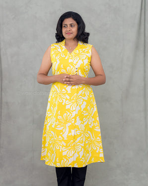 A women wearing yellow color cotton a-line kurti with back rope on a grey background