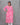Woman wearing a pink floral kurti against a gray background