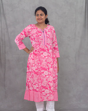 Woman wearing a pink floral kurti against a gray background