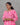 Woman wearing a pink and white patterned kurti against a gray background
