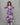 Woman wearing a purple and white patterned dress against a gray background