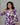 Woman wearing a purple and white patterned dress against a gray background