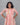 Woman wearing a patterned dress against a gray background