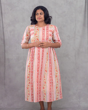 Woman wearing a patterned dress against a gray background