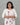 A women wearing a printed beige color cotton kurti on a grey background
