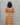 Person wearing a yellow patterned dress against a gray background