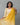 A women wearing yellow color printed modal kurti suit with plain bottom and a dual color dupatta on a grey background