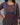 A lady wearing a printed black cotton kurti on a grey background