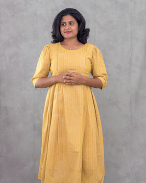Woman wearing a yellow dress against a gray background