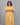 Woman wearing a yellow dress against a gray background