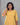Woman wearing a yellow dress against a gray background
