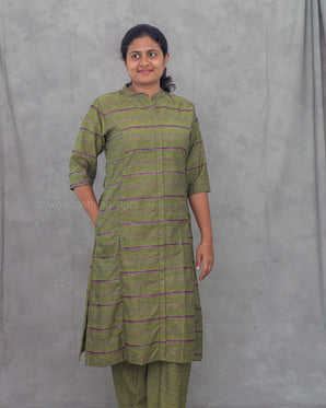 Woman wearing a green and purple striped kurti with matching pants against a gray background