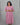Woman wearing a pink dress against a gray background