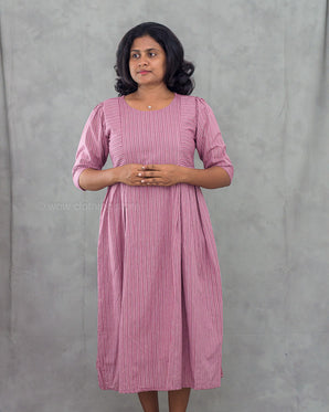 Woman wearing a pink dress against a gray background