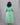 Person wearing a green dress against a gray background