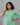 Woman wearing a green dress against a gray background