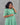 Woman wearing a green dress against a gray background