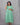 Woman wearing a green dress against a gray background