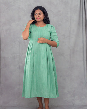 Woman wearing a green dress against a gray background