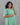Person wearing a green dress against a gray background
