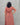 Person wearing a red and orange striped dress against a gray background