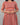 Person wearing a red and orange striped dress against a gray background