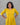 Woman wearing a yellow dress against a gray background