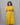 Woman wearing a yellow dress against a gray background
