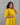 Woman wearing a yellow dress against a gray background