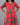 Person wearing a red and green patterned dress against a gray background