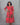 Woman wearing a red and green patterned dress against a gray background