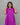 Woman wearing a violet maternity dress with white patterns against a gray background